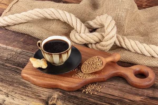 Instant granulated coffee. Coffee beans on or instant granulated coffee. Dry instant coffee in a black ceramic dish next to coffee beans isolated.