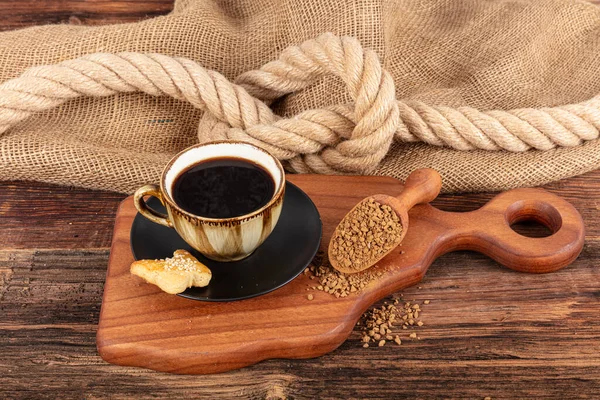 インスタントグラルコーヒー コーヒー豆は または瞬時に粒状にされたコーヒーです 隔離されたコーヒー豆の隣の黒い陶磁器皿の乾燥したインスタントコーヒー ストック画像
