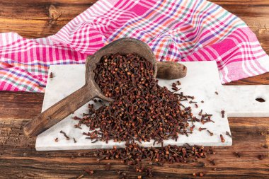 Kuru baharat karanfilleri. Karanfiller ahşap zemine saçılmış. Karanfil rustik arka plan baharat kavramı.