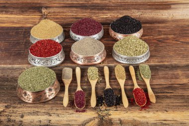 Tabaklarda yemek pişirmek için çeşitli otlardan ve baharatlardan renkli bir arka plan. Baharat ve otlar arka planda. Çeşitli çeşniler, baharatlar. Yemek malzemeleri, lezzet