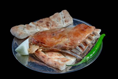 Pita ekmeğinde kemikli kuzu kaburgası. Kuzu pirzolası Tandoori usulü ve yeşil biber ve soğanlı çivi pidesi. Türk mutfağı.