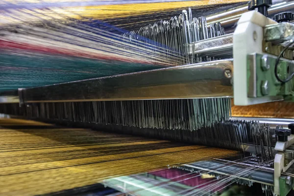 现代地毯织造厂 地毯缝纫机针 纱布箱连接在地毯织机上 织物织造厂内部 图库照片