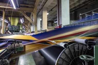 Halı fabrikası için sentetik iplikler, halı üretimi, dokuma tezgahları. Bir halı dokuma fabrikasının içinde. Tekstil Dokuma Değirmeninde Spool Dikiş Rafı.