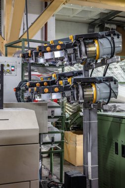 Halı fabrikası için sentetik iplikler, halı üretimi, dokuma tezgahları. Bir halı dokuma fabrikasının içinde. Tekstil Dokuma Değirmeninde Spool Dikiş Rafı.