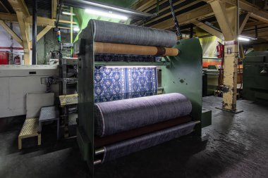 Halı fabrikası için sentetik iplikler, halı üretimi, dokuma tezgahları. Bir halı dokuma fabrikasının içinde. Tekstil Dokuma Değirmeninde Spool Dikiş Rafı.