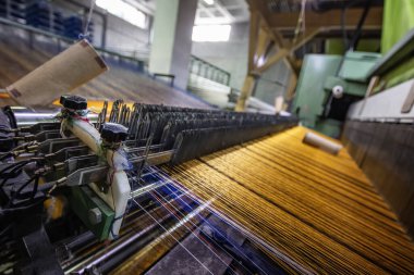 Halı fabrikası için sentetik iplikler, halı üretimi, dokuma tezgahları. Bir halı dokuma fabrikasının içinde. Tekstil Dokuma Değirmeninde Spool Dikiş Rafı.