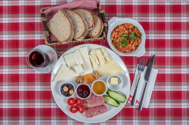 Türk Mutfağı Kahvaltı Tabağı. Dilimlenmiş kiraz domatesli beyaz kahvaltı tabağı, salatalık ve ahşap masada haşlanmış yumurta..