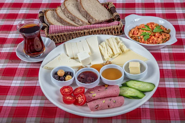 Türk Mutfağı Kahvaltı Tabağı. Dilimlenmiş kiraz domatesli beyaz kahvaltı tabağı, salatalık ve ahşap masada haşlanmış yumurta..