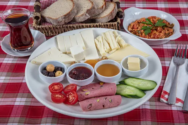 Türk Mutfağı Kahvaltı Tabağı. Dilimlenmiş kiraz domatesli beyaz kahvaltı tabağı, salatalık ve ahşap masada haşlanmış yumurta..