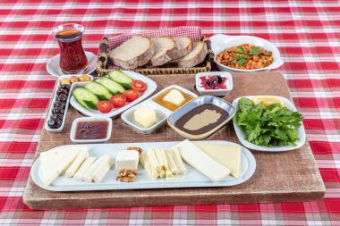 Türk Mutfağı Kahvaltı Tabağı. Geleneksel lezzetli Türk kahvaltısı, yemek konsepti fotoğrafı. Zengin çeşit peynir, domates, salatalık, yumurta, ahşap arka planda reçel..