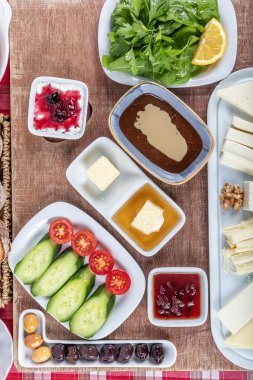 Türk Mutfağı Kahvaltı Tabağı. Geleneksel lezzetli Türk kahvaltısı, yemek konsepti fotoğrafı. Zengin çeşit peynir, domates, salatalık, yumurta, ahşap arka planda reçel..