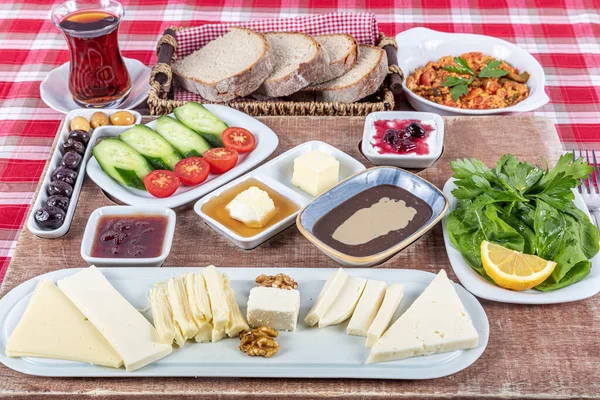 Türk Mutfağı Kahvaltı Tabağı. Geleneksel lezzetli Türk kahvaltısı, yemek konsepti fotoğrafı. Zengin çeşit peynir, domates, salatalık, yumurta, ahşap arka planda reçel..