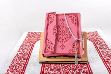 İstanbul, Türkiye - 28 Ocak 2024; Kur 'an namaz örtüsü üzerine. Kuran ve müslüman dua boncukları İslami namaz minderinin üzerinde. İslam 'ın sembolü.