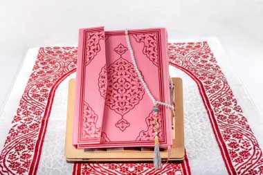 İstanbul, Türkiye - 28 Ocak 2024; Kur 'an namaz örtüsü üzerine. Kuran ve müslüman dua boncukları İslami namaz minderinin üzerinde. İslam 'ın sembolü.