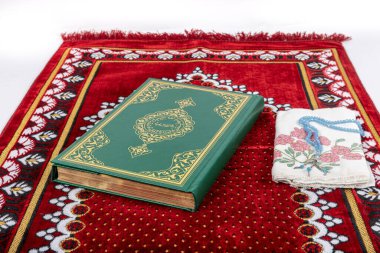 Kuran ve tespihlerin ibadet halılarında sergilendiği muhteşem bir yer. İslami dua aksesuarları, ibadet halısında Kur 'an tespihi, üst manzara..