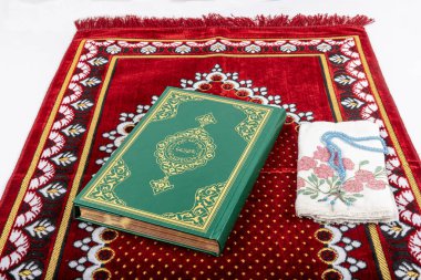 Kuran ve tespihlerin ibadet halılarında sergilendiği muhteşem bir yer. İslami dua aksesuarları, ibadet halısında Kur 'an tespihi, üst manzara..