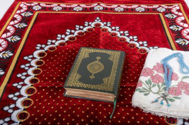 Kuran ve tespihlerin ibadet halılarında sergilendiği muhteşem bir yer. İslami dua aksesuarları, ibadet halısında Kur 'an tespihi, üst manzara..