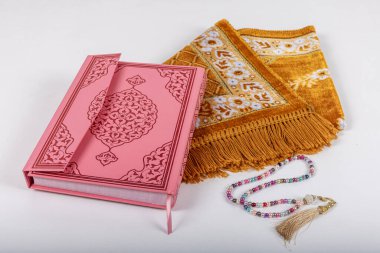 Kuran ve tespihlerin ibadet halılarında sergilendiği muhteşem bir yer. İslami dua aksesuarları, ibadet halısında Kur 'an tespihi, üst manzara..