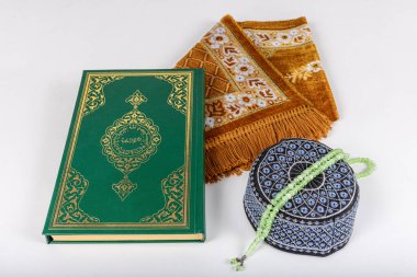 Kuran ve tespihlerin ibadet halılarında sergilendiği muhteşem bir yer. İslami dua aksesuarları, ibadet halısında Kur 'an tespihi, üst manzara..