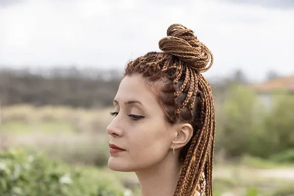 African American Women with Hair Braided into Cornrows Hairstyle Using Synthetic Hair Extensions. Texture of thin brown African braids, close-up braided hair, Afro style.
