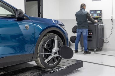 İstanbul Türkiye 23 Mart 2023; Araç tekerleği dengeleme servisi. Lastik servisinde araba tekerleği dengeleniyor. Lastik servisinde tekerlek dengeleme makinesiyle çalışan tamirci, kapat.