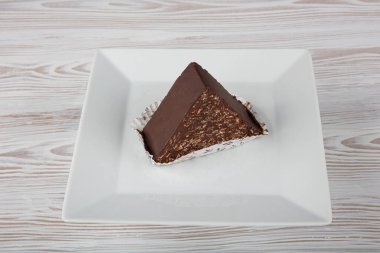 Çikolata ve çikolata soslu bisküvi keki. Porselen tabakta çikolatalı mozaik kek..