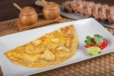 Sebze salatalı omlet. Bir tabağa tipik bir tortilla de patata ile yakın plan, İspanyol omleti, bir set masasında..