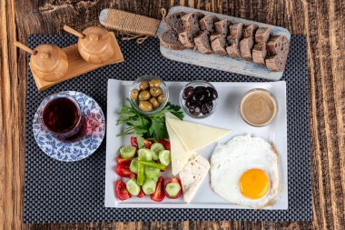Türk Mutfağı Kahvaltı Tabağı. Beyaz ahşap masada zengin ve lezzetli Türk kahvaltısı. Parlak sabahlarda sağlıklı Türk kahvaltısı; metin için boşluk kopyala.