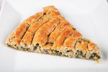 Susam tohumları, ıspanak ve peynir ile süslenmiş, fillo hamurundan yapılmış lezzetli bir pasta. Geleneksel Türk Pastası ıspanaklı börek. Türkçe adı: Ispanakli Borek.