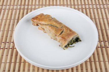 Susam tohumları, ıspanak ve peynir ile süslenmiş, fillo hamurundan yapılmış lezzetli bir pasta. Geleneksel Türk Pastası ıspanaklı börek. Türkçe adı: Ispanakli Borek.