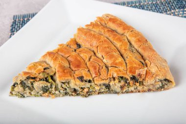 Susam tohumları, ıspanak ve peynir ile süslenmiş, fillo hamurundan yapılmış lezzetli bir pasta. Geleneksel Türk Pastası ıspanaklı börek. Türkçe adı: Ispanakli Borek.