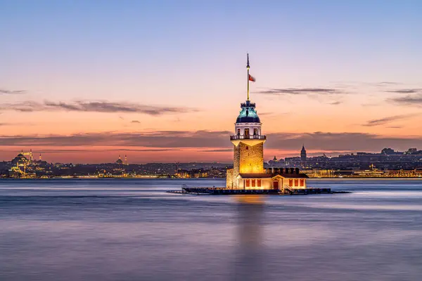 stock image iery sunset over Bosphorus with famous Maiden's Tower (Kiz Kulesi) also known as Leander's Tower, symbol of Istanbul, Turkey. Scenic travel background for wallpaper or guide book