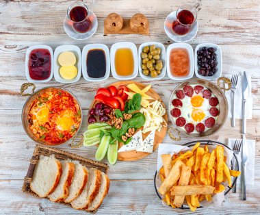 Geleneksel lezzetli modern Türk mutfağı. Bakır yumurta tabakları, borek ve simit, reçel, zeytin, peynir, sebze ve Türk çayı gibi hamur işleri ile sade Türk kahvaltısı.