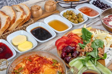 Geleneksel lezzetli modern Türk mutfağı. Bakır yumurta tabakları, borek ve simit, reçel, zeytin, peynir, sebze ve Türk çayı gibi hamur işleri ile sade Türk kahvaltısı.