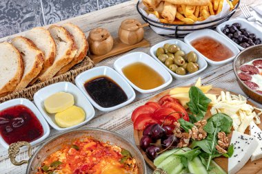 Geleneksel lezzetli modern Türk mutfağı. Bakır yumurta tabakları, borek ve simit, reçel, zeytin, peynir, sebze ve Türk çayı gibi hamur işleri ile sade Türk kahvaltısı.