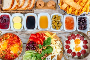 Geleneksel lezzetli modern Türk mutfağı. Bakır yumurta tabakları, borek ve simit, reçel, zeytin, peynir, sebze ve Türk çayı gibi hamur işleri ile sade Türk kahvaltısı.