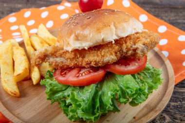 Tavuk burger. Lezzetli fast food taze hamburgerler kızarmış chikcen ve sebzeler koyu arka planda izole edilmiş..