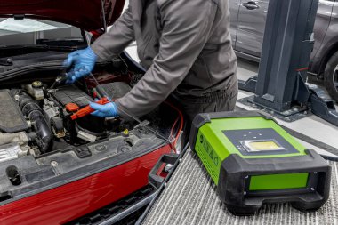 Arızalı araba elektriğini başlatmak için şarj etmek, pilin enerjisi ya da şarjı bitmişti. Taşınabilir şarj aleti, pozitif negatif klemp, kırmızı siyah kablo gibi ekipman araçları ekle.