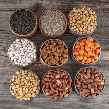 Kırsal masada fındık ve tohum çeşitleri. Bakır kasede karışık atıştırmalıklar. Çeşitli fındıklar (nohut, nohut, fıstık, fındık). Vejetaryen yemeği. Sağlıklı yeme kavramı.