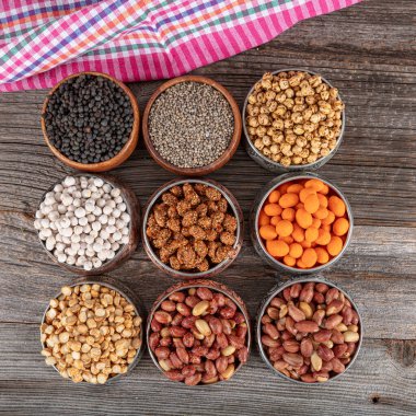 Assortment of nuts and seed on rustic table. Mixed snacks in a copper bowl. Background of various nuts (Chickpeas, chickpeas, peanuts, hazelnut). Vegetarian meal. Healthy eating concept. clipart