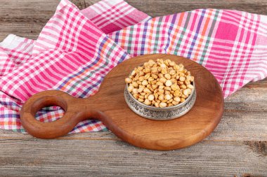 Kırık kızarmış nohut ikiye bölünmüş. Kızarmış sarı yarım nohut, geleneksel Türk fıstığı, leblebi. Bakır bir kase kızarmış nohut..