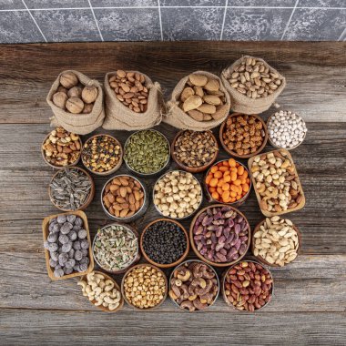 Fındık ve tohum çeşitleri. Atıştırmak için karışık çiğ yiyecekler, üst manzara. Farklı fındık geçmişi. Kolaj fındıkları ve çekirdekler kabukta, üst manzara. Sağlıklı beslenme geçmişi var..