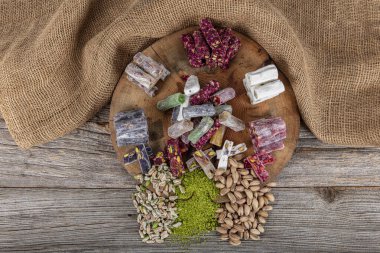 Ahşap zemin üzerinde şam fıstığı fitili olan Türk lezzeti çeşitleri. Geleneksel Türk mutfağı lezzetleri. Karışık Wick Türk Lokumu ve Pistachio yerel adı; Fistikli Karisik fitil lokum.