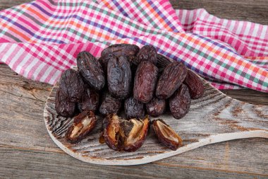 Büyük boy Kudüs Randevu meyvesi. Mermer tepside, ahşap masa arkaplanındaki gümüş kasede hurma meyvesi yakın çekim. Kuru hurma meyvesi atıştırmalık kadar sağlıklıdır..