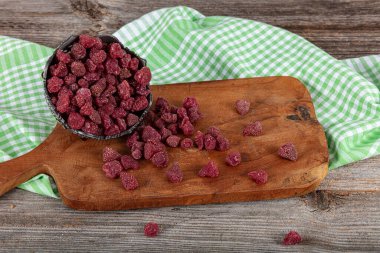 Kurutulmuş çilek. Tahta masada kurutulmuş çilek kasesi..