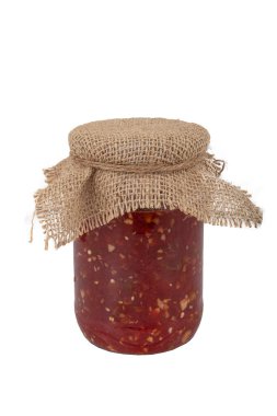 Kavanozda ev yapımı biber ve domates ezmesi. Beyaz arkaplanda izole edilmiş bir kavanoza domates yapıştırıcısı.