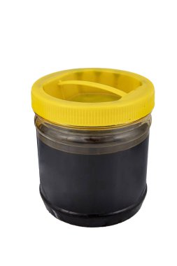 Grape molasses in a plastic jar on a white background. Jar of grape molasses, grape syrup. Grape molasses is natural,sweet,delicious and black clipart
