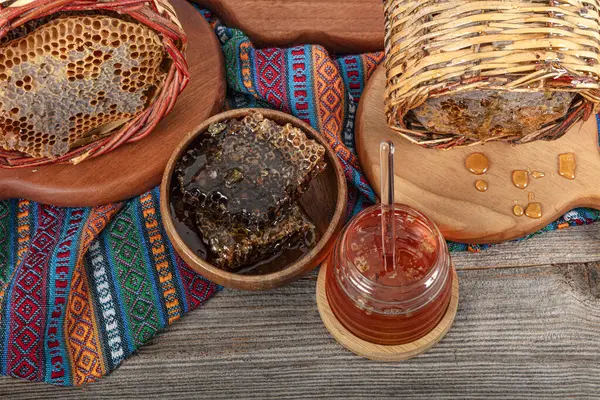 stock image Magical honeycomb close up, Honey harvesting, honey picking. Organic honeycomb (Turkish Karakovan Honey). Organic honeycomb in jar with honey dipper on vintage wooden background.