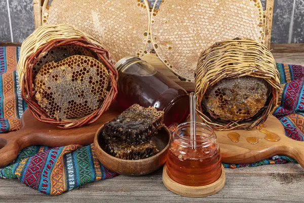 stock image Magical honeycomb close up, Honey harvesting, honey picking. Organic honeycomb (Turkish Karakovan Honey). Organic honeycomb in jar with honey dipper on vintage wooden background.