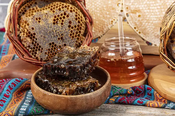 stock image Magical honeycomb close up, Honey harvesting, honey picking. Organic honeycomb (Turkish Karakovan Honey). Organic honeycomb in jar with honey dipper on vintage wooden background.